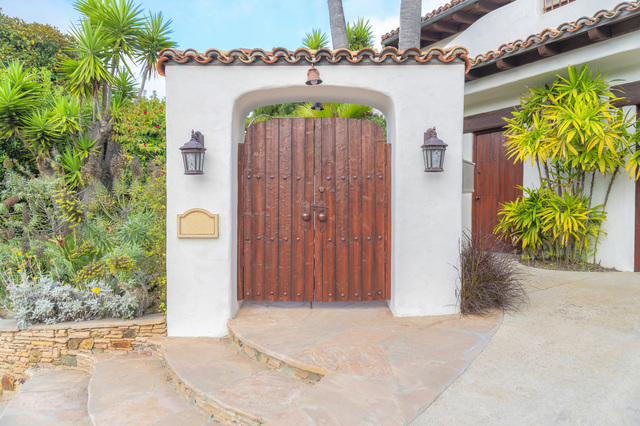 Wooden arbor gate with wall lamps on the white posts at La Jolla, San Diego, California